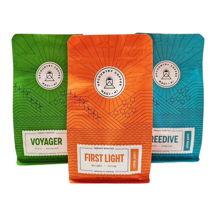 Green, orange and blue printed coffee bags with landscape line artwork