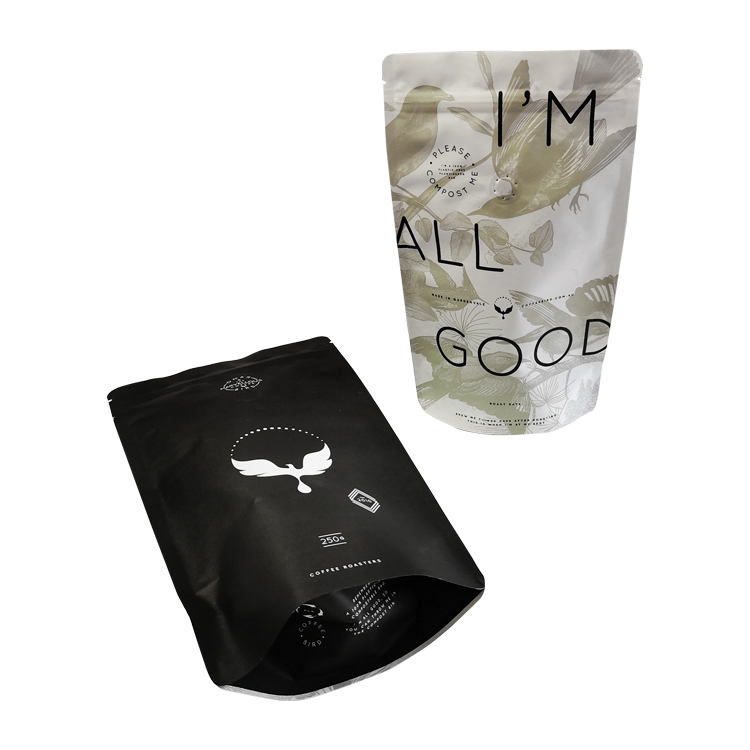 A black coffee pouch and a white pouch with green botanical artwork