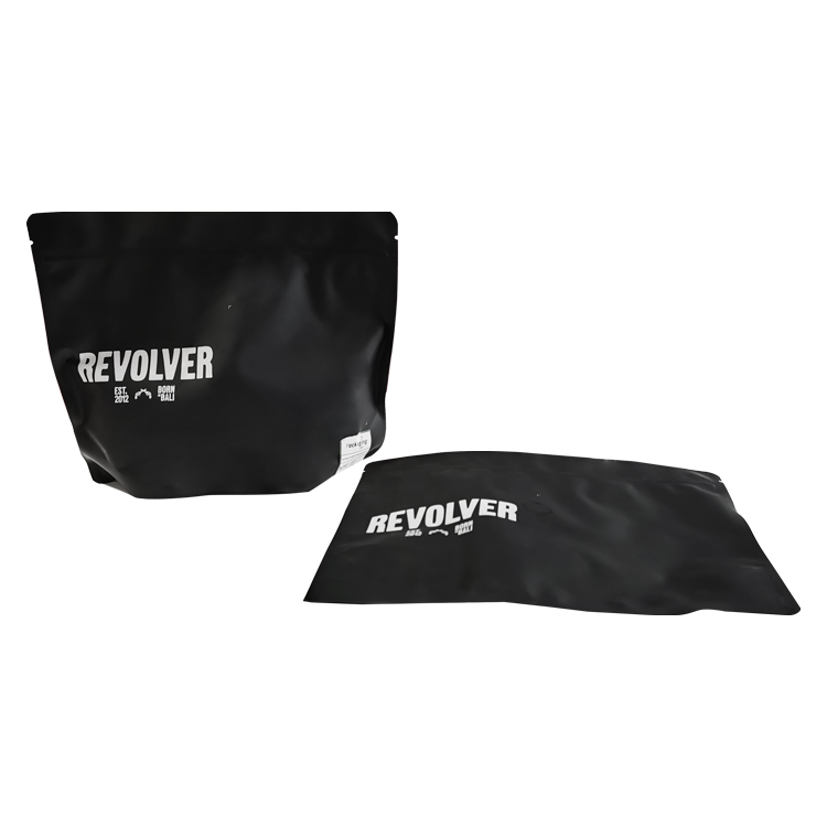 Black stand up coffee pouch upright beside a laid-down pouch