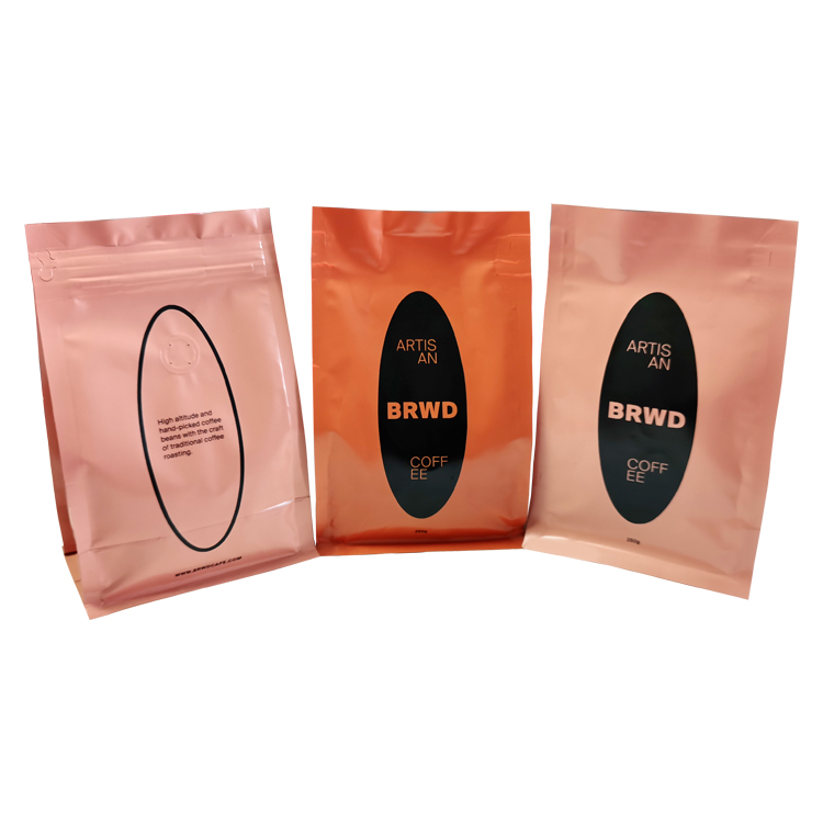 Three peach-colored coffee bags showing front and back artwork