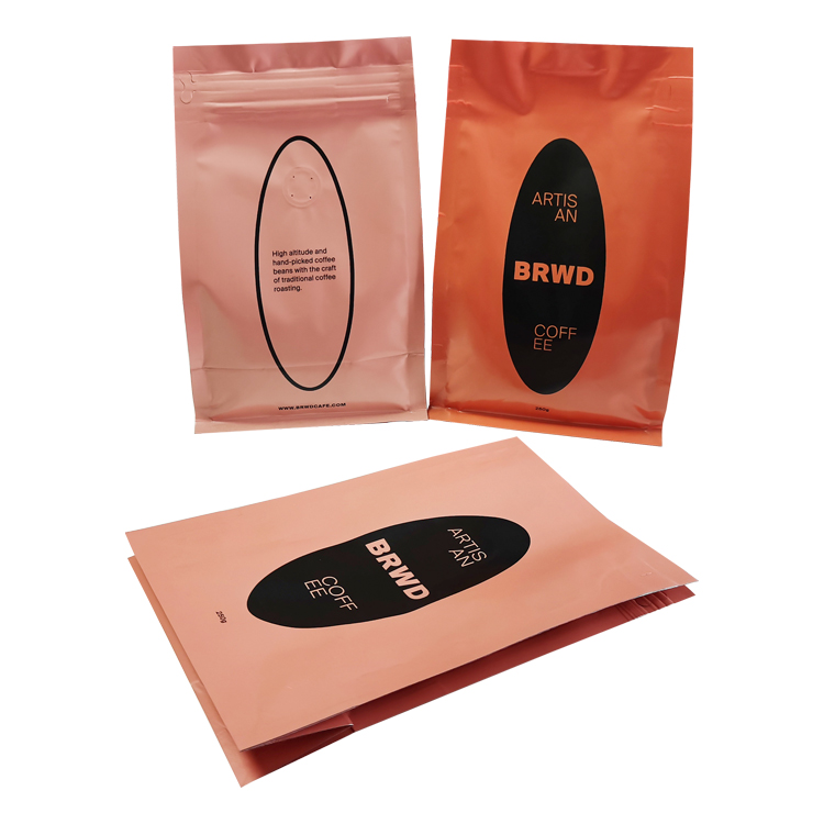 Peach back and orange front beside a laid-down peach coffee bag