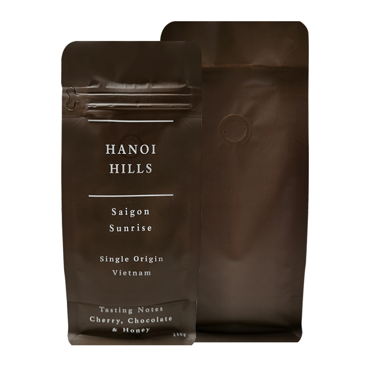 Front and back of dark brown coffee bags with opening details and a valve