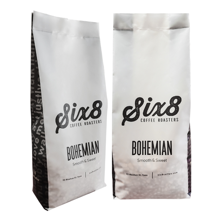 Angled white coffee bags showing black graphics along the side gussets