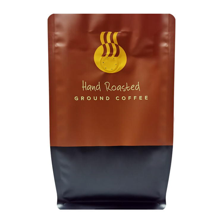 Front of a brown coffee bag with yellow cup artwork and black lower panel