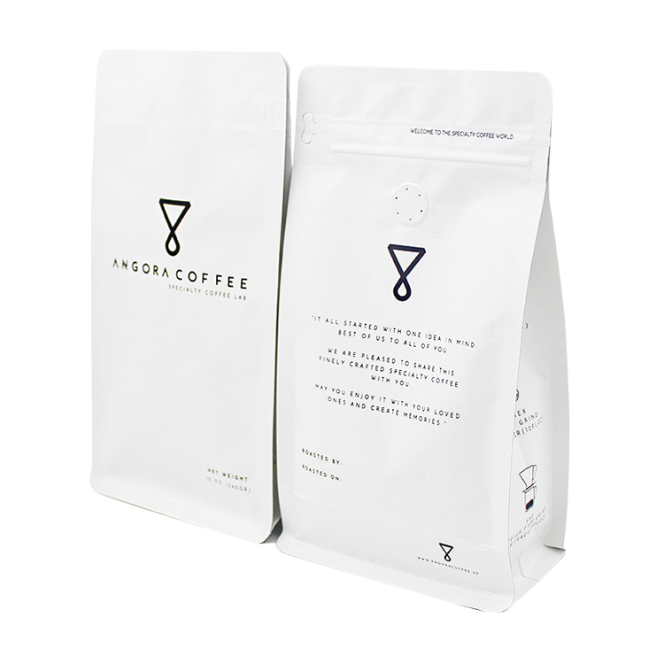 Two white coffee bag views with black brand graphics, a round valve and a small scissors symbol on one side panel