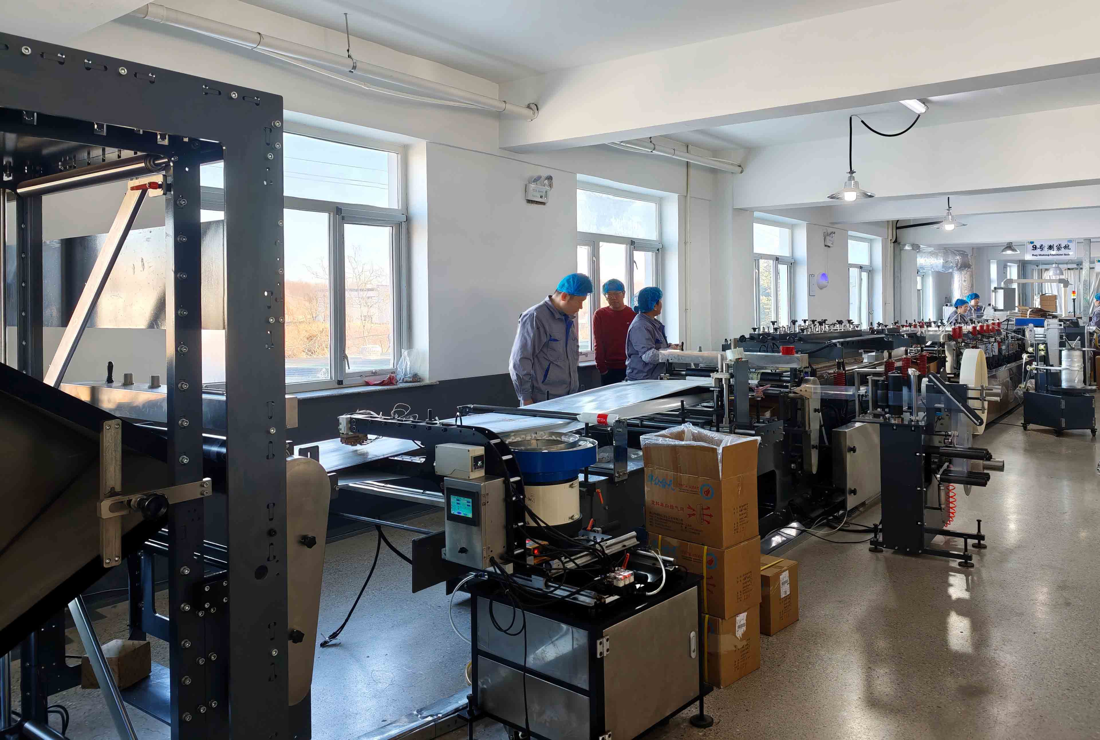 Pouch-making machinery and operators on the packaging production floor